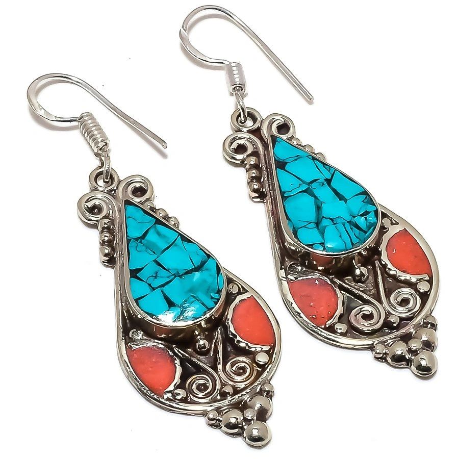 A pair of earrings with turquoise and coral.