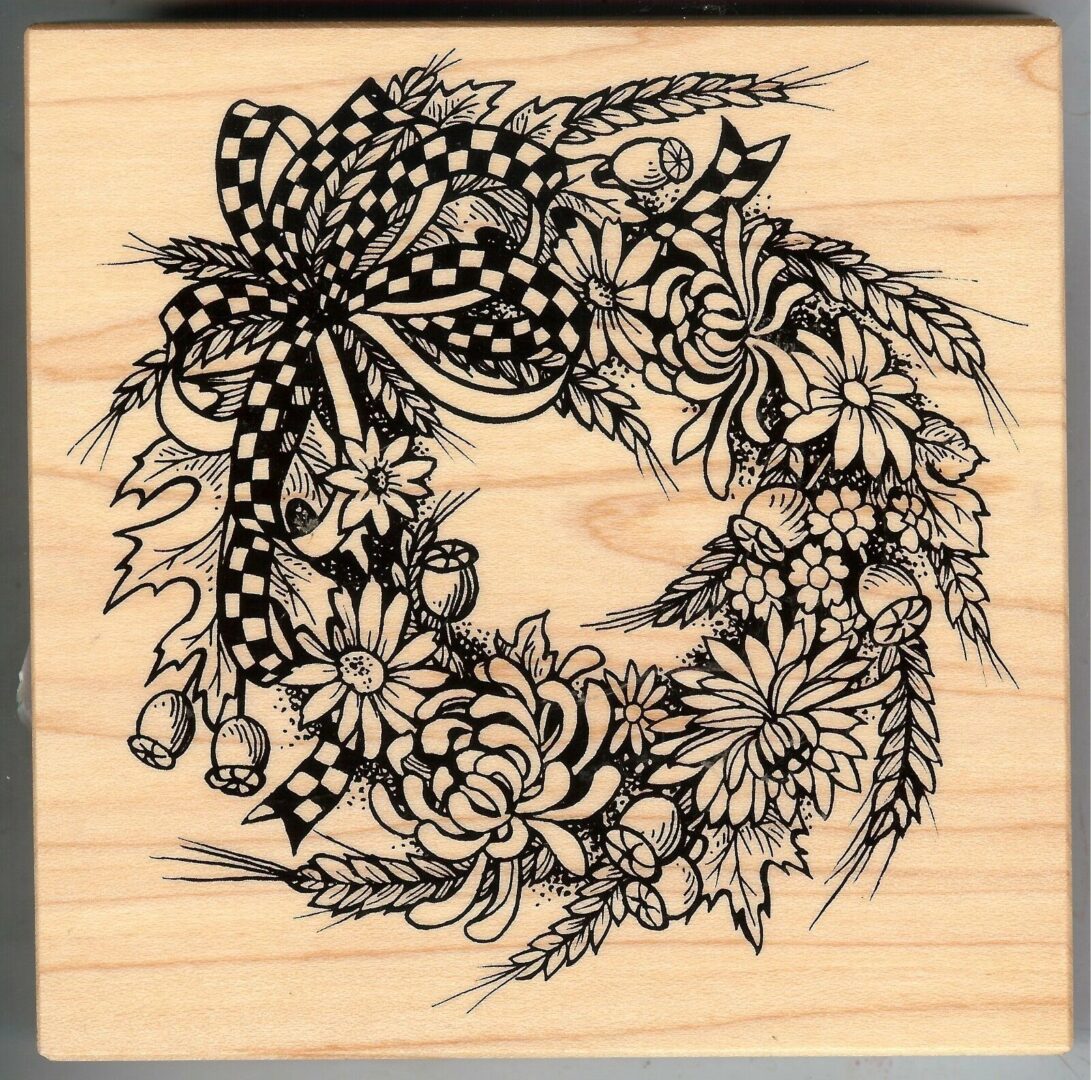 A wooden block with a wreath of flowers on it.
