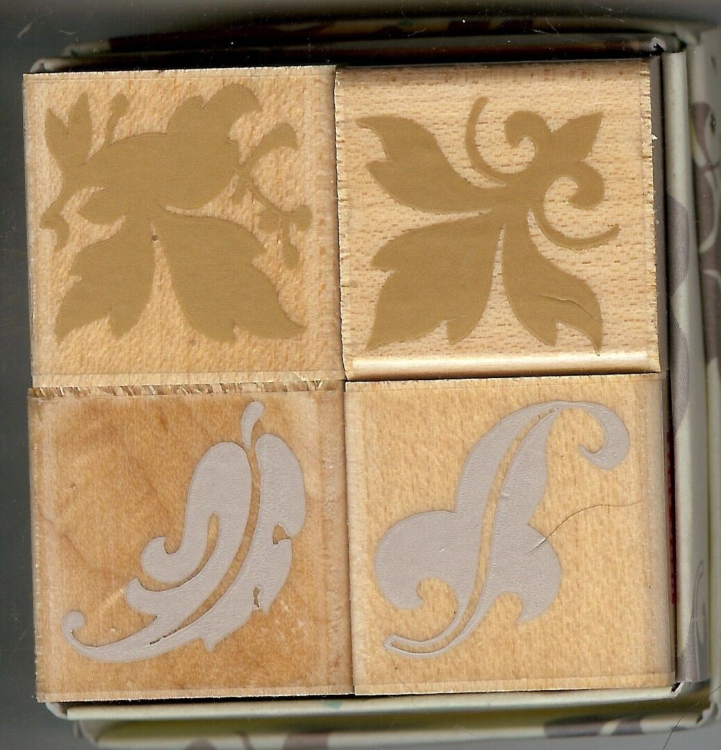 A box of four wooden stamps with different designs.