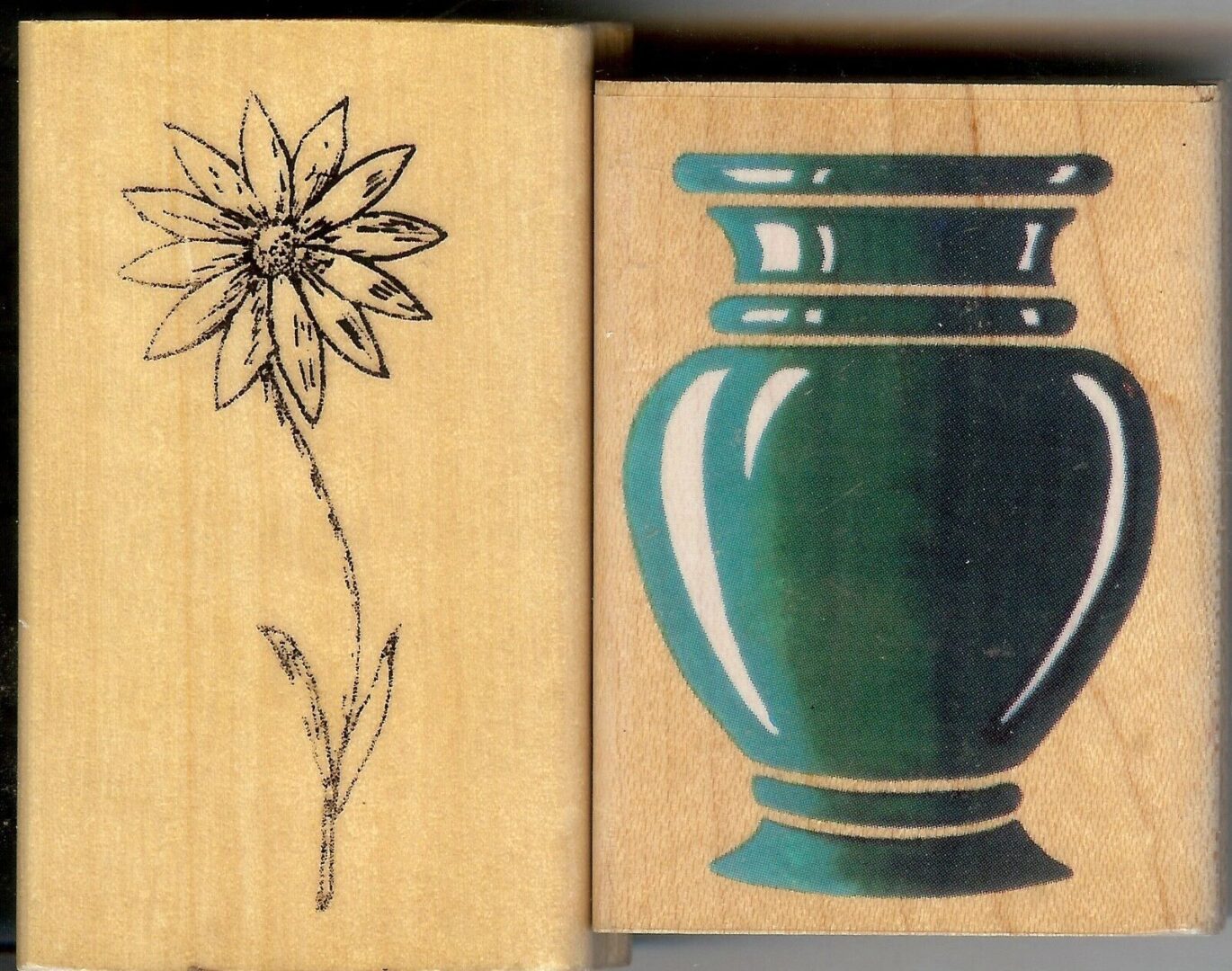A flower and vase on two different wooden blocks.