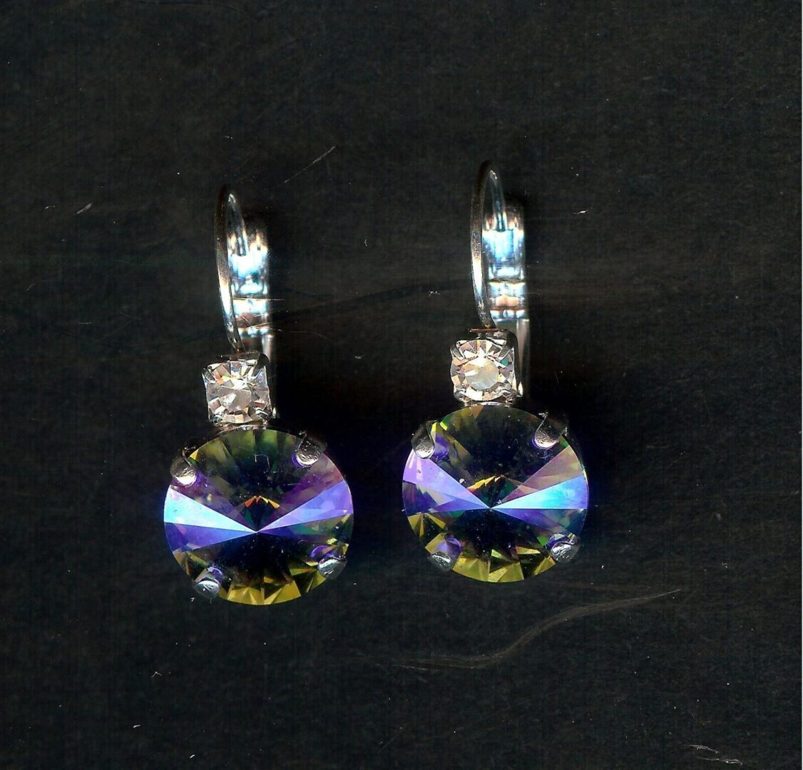 A pair of earrings with a purple and blue crystal.
