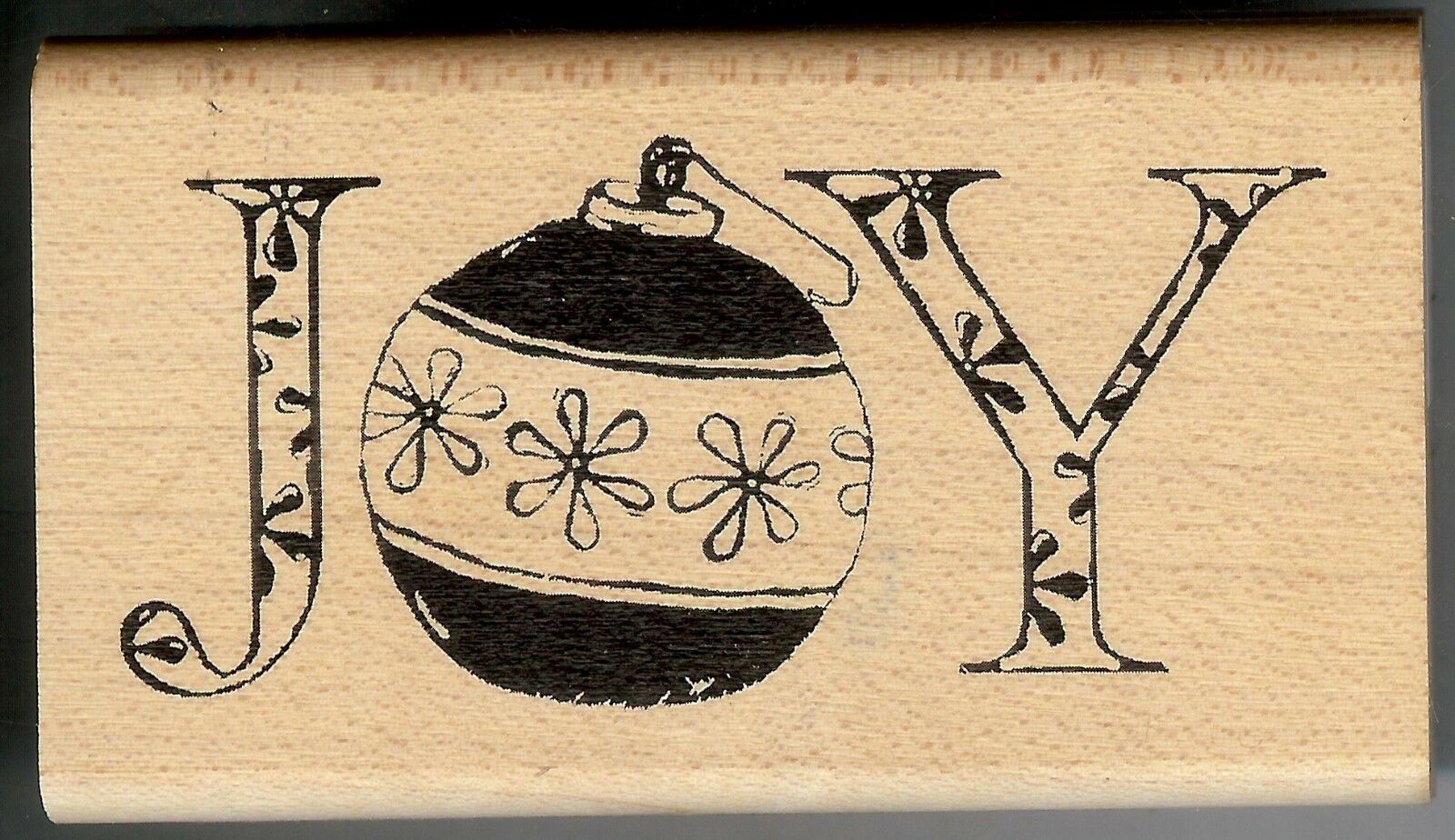 A black and white christmas ornament with the word joy in front of it.