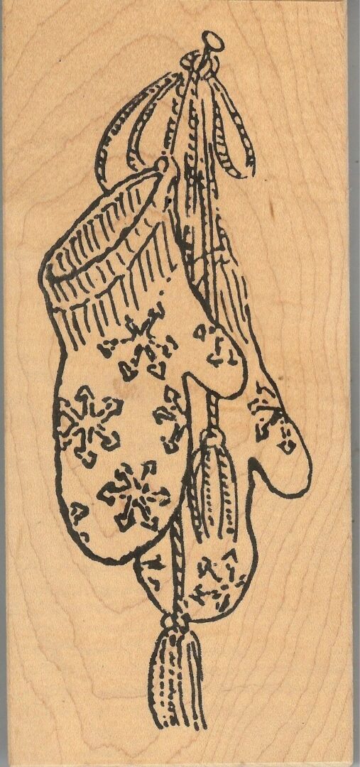 A wooden stamp with a pair of mittens and a scarf.