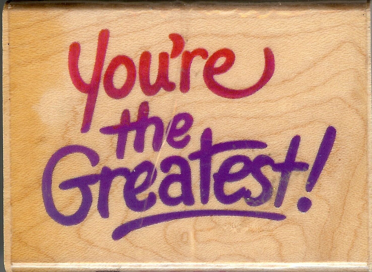 A wooden plaque with the words " you 're the greatest !" written on it.