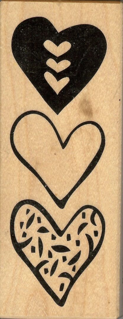 A wooden stamp with three different hearts on it.