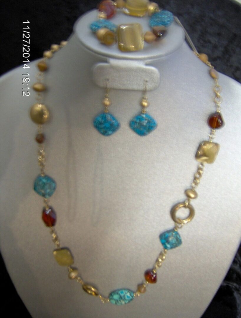 A necklace and earrings set with blue beads.