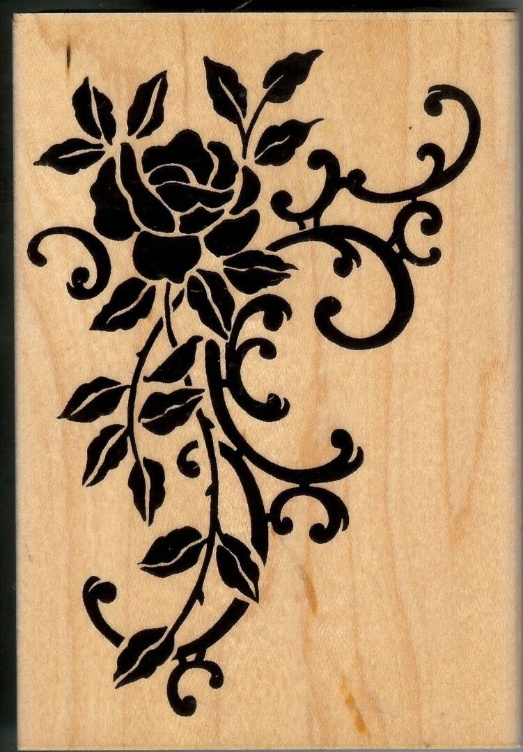 A wooden plaque with a black rose on it.