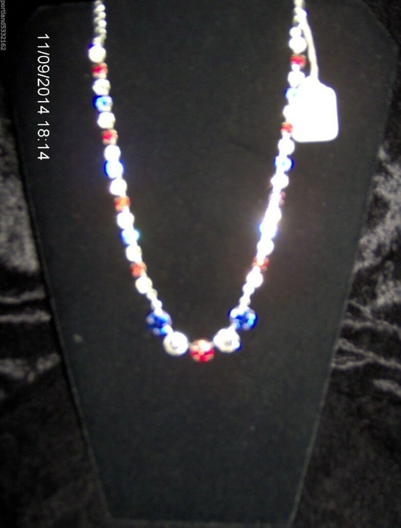 A necklace with red, white and blue beads on it.