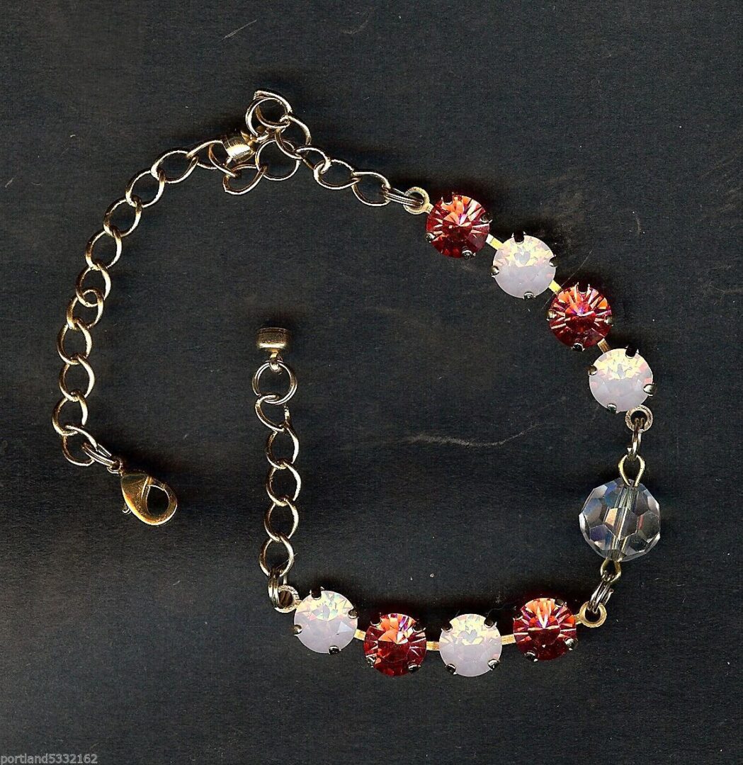 A bracelet with red and white beads on it.