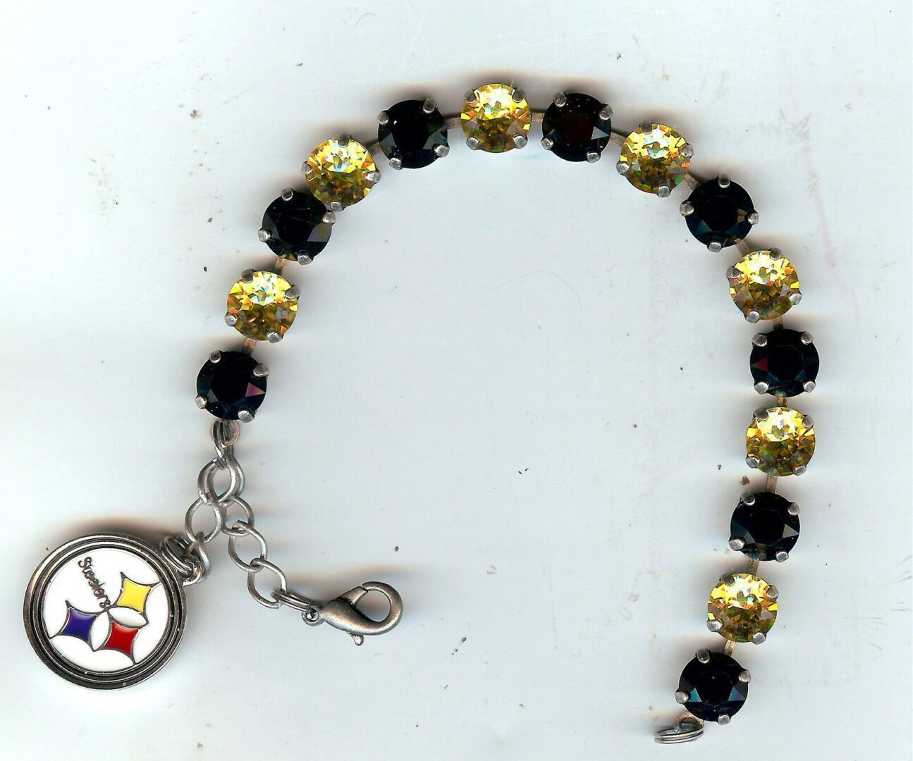 A black and gold bracelet with a steelers charm.