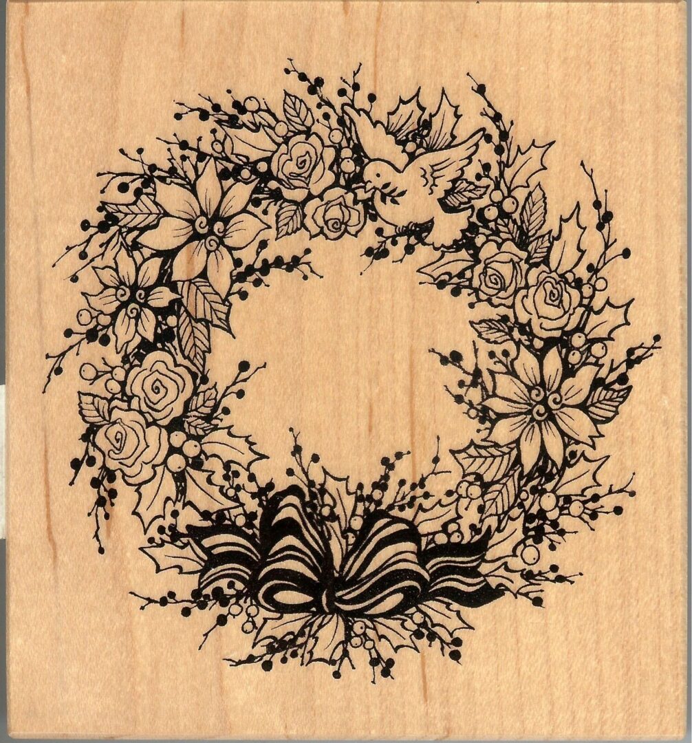 A wooden picture of a wreath with flowers.