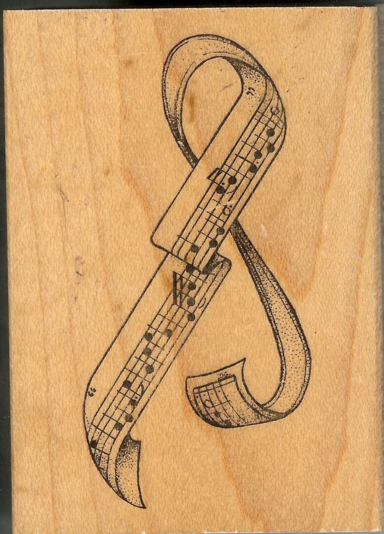 A wooden stamp with musical notes and a ribbon.