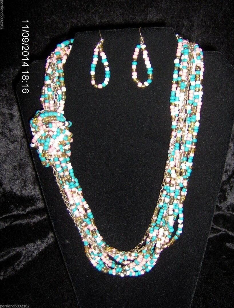 A necklace and earrings set with turquoise, white and gold beads.