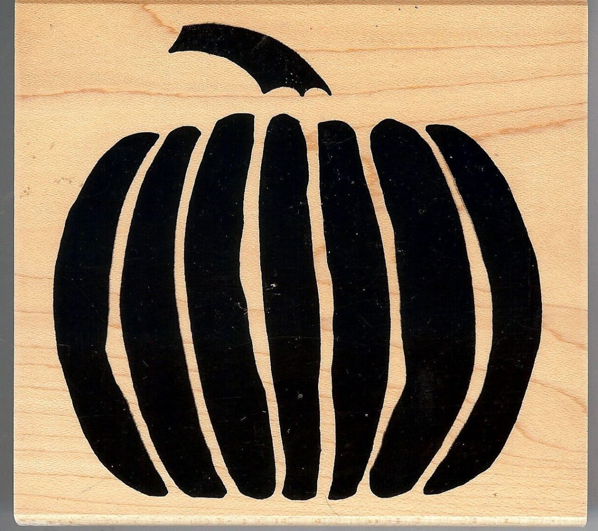 A pumpkin is shown on a wooden background.