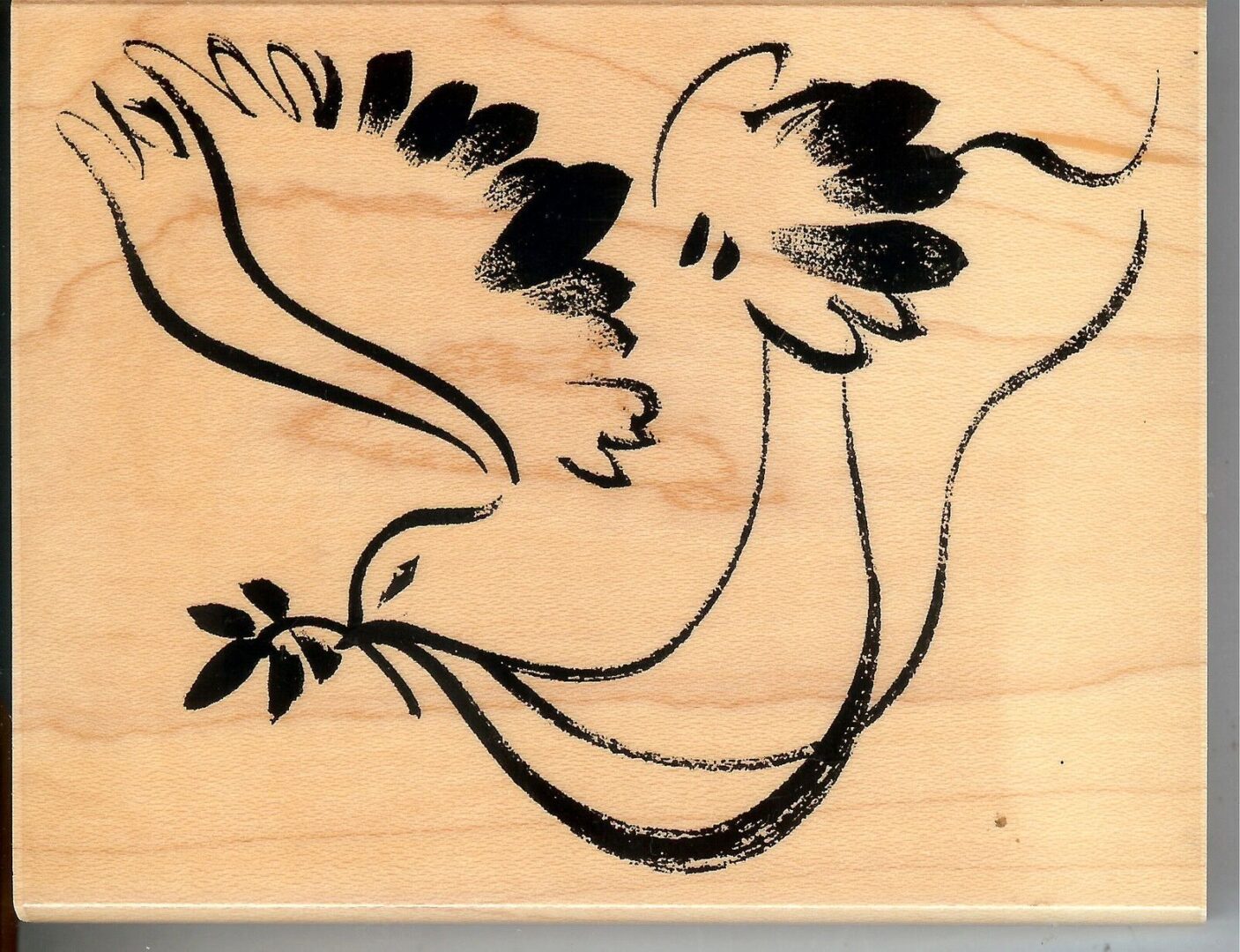 A bird with a branch in its mouth on top of a wooden block.
