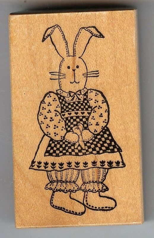 A bunny rabbit sitting on top of a wooden block.