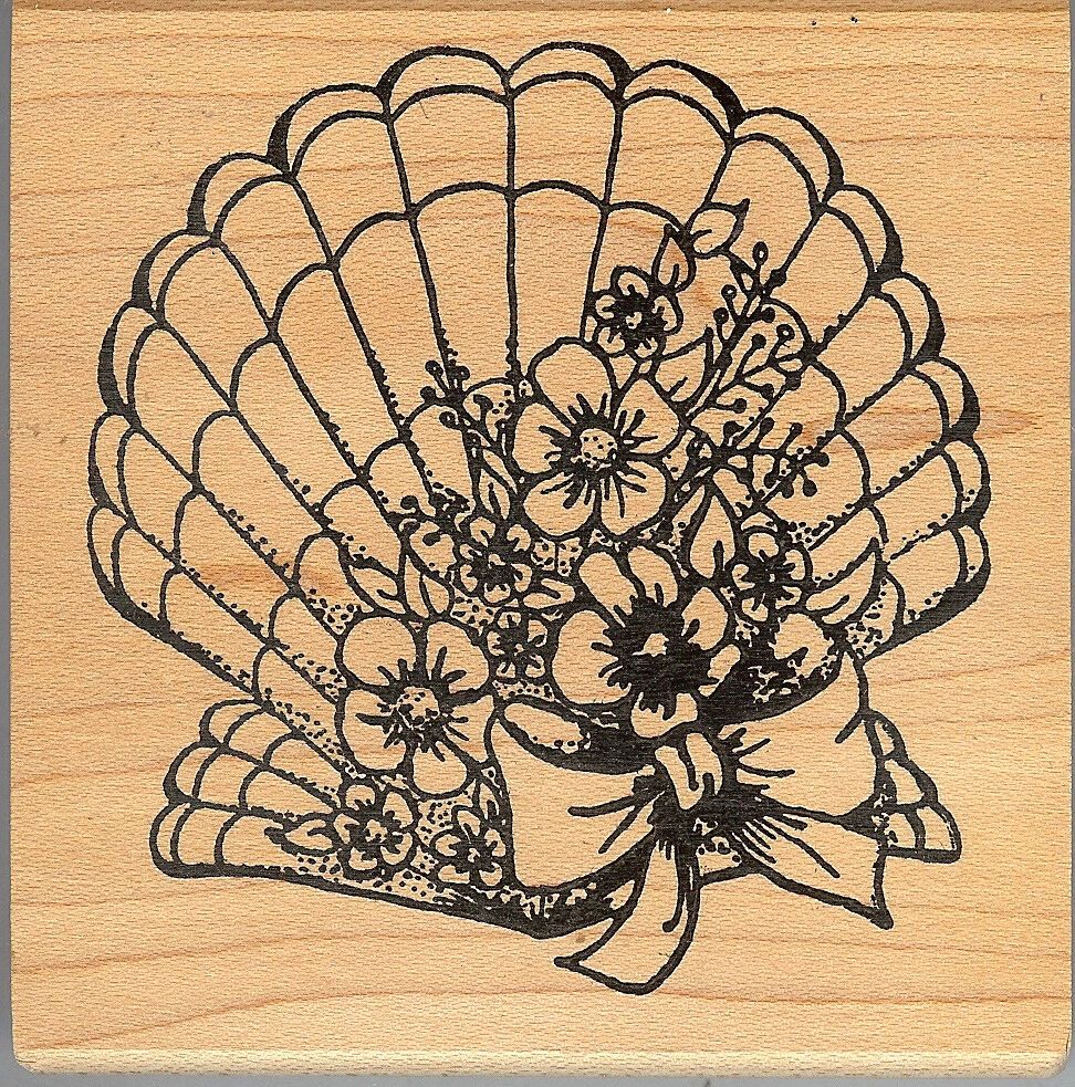 A scallop shell with flowers and ribbon on it.