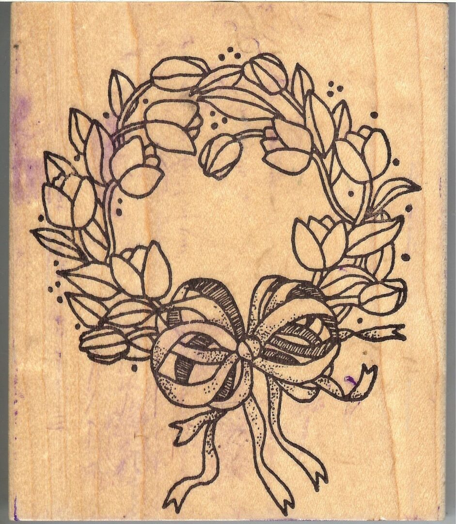 A wooden stamp with a bow and leaves
