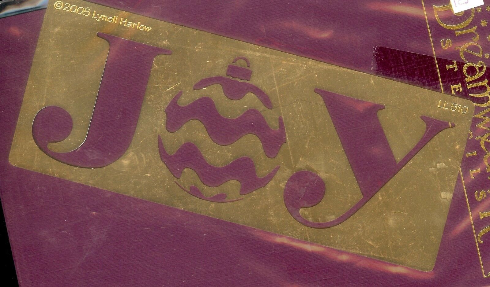 A close up of the word joy in gold on a purple background