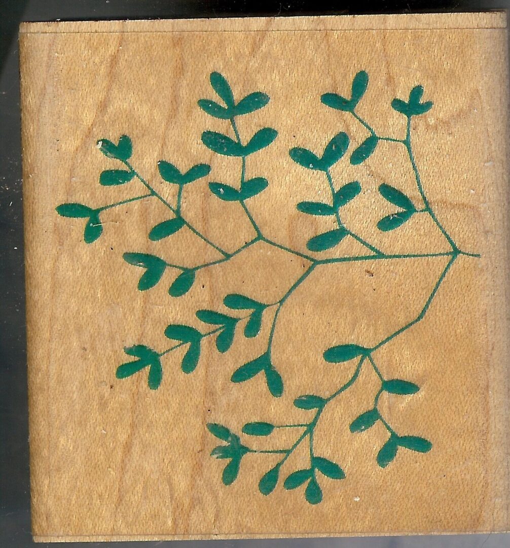 A wooden block with green leaves on it.