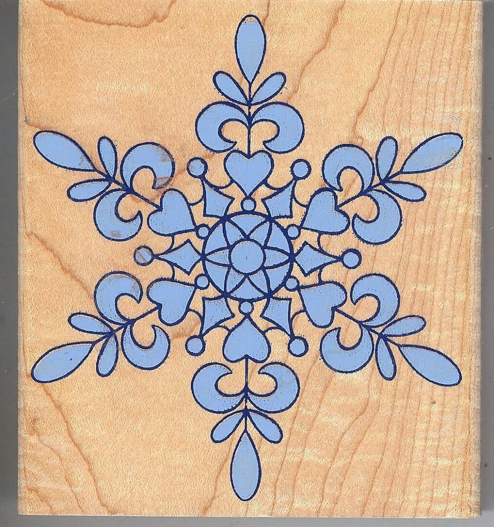 A wooden block with a blue snowflake on it.