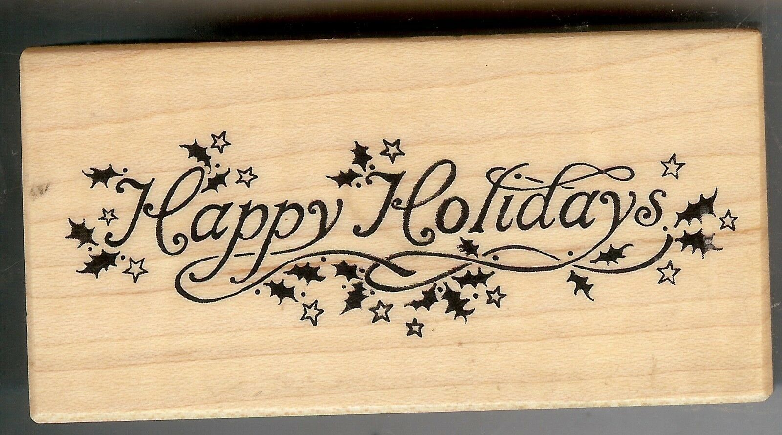 A wooden stamp with the words " happy holidays ".