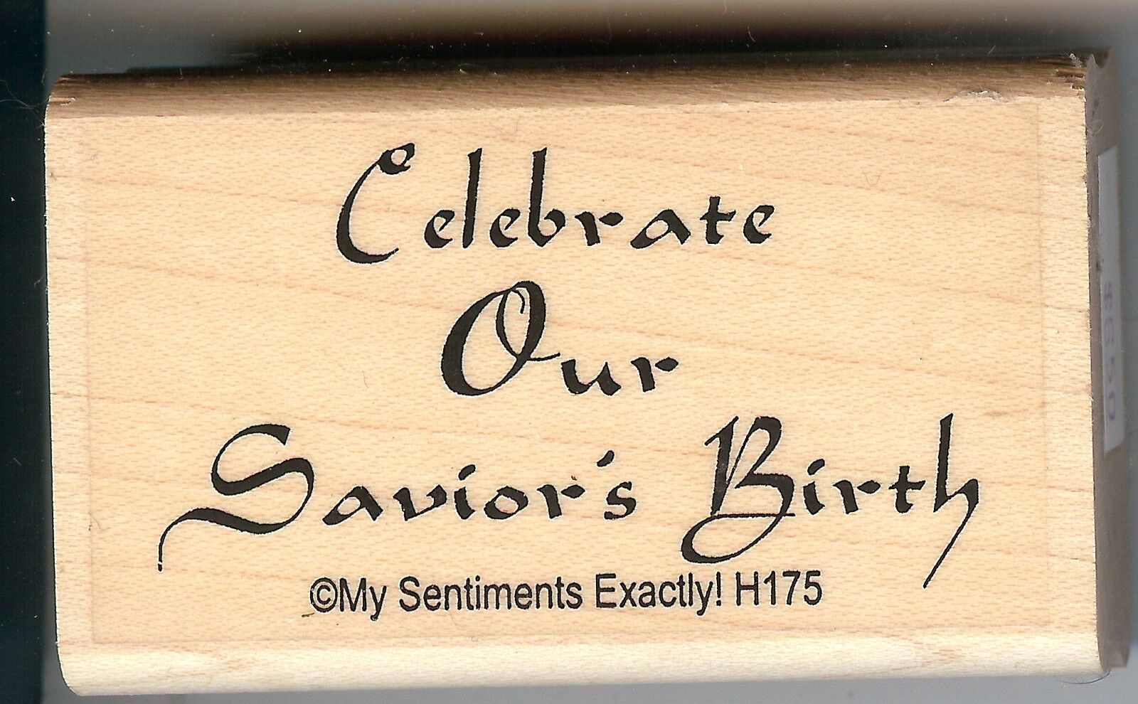 A wooden block with the words celebrate our savior 's birth.