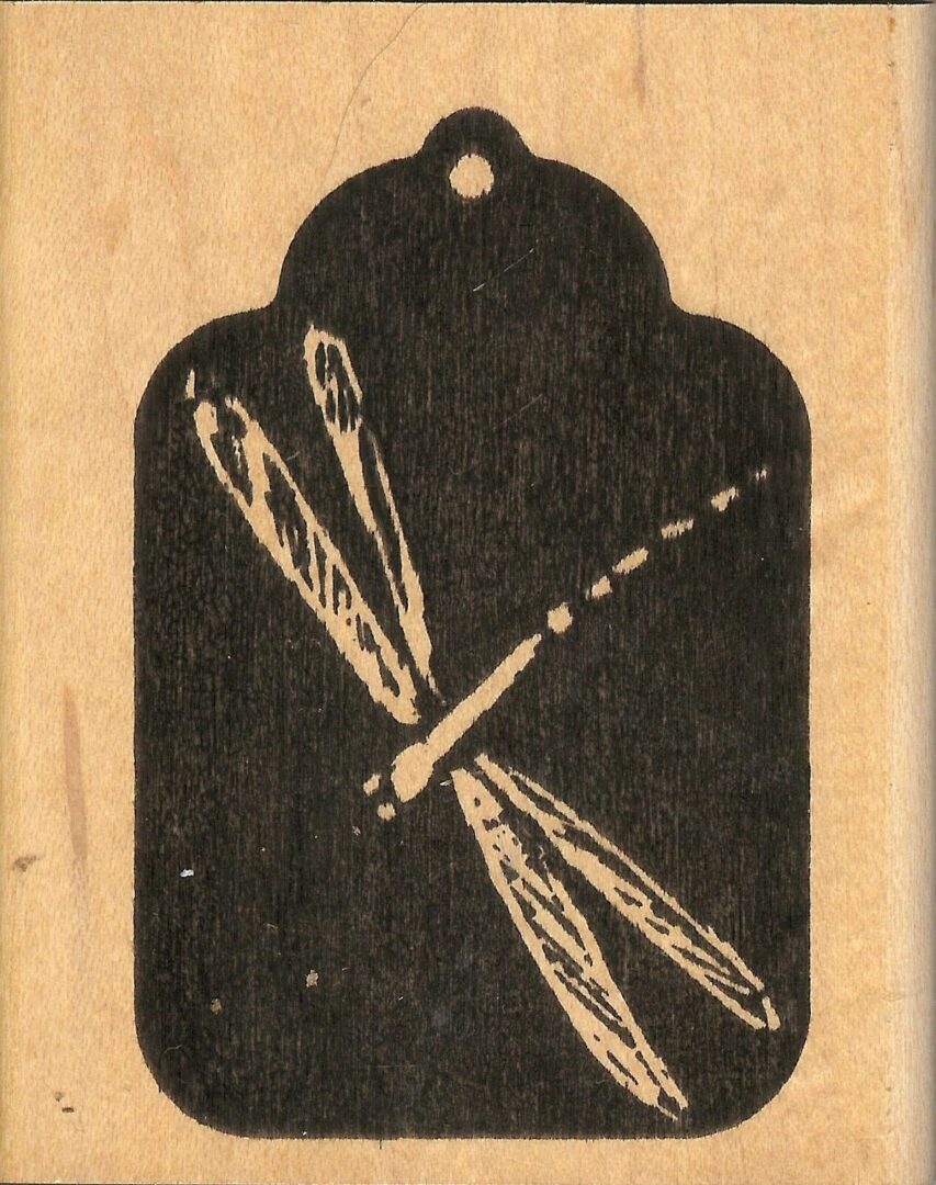 A black and white picture of a tag with a dragonfly on it.