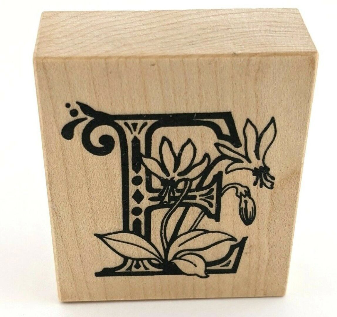 A wooden block with the letter e and flowers.