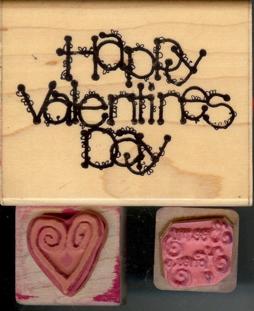 A wooden block with the words happy valentines day written on it.